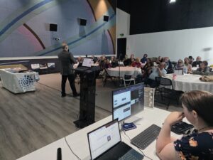 A speaker addresses residents at SALA during the October 22, 2026 LANet and Atomic Fiber community meeting.